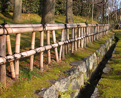Elaborate Natural Bamboo Fencing next to a ditch and woodland